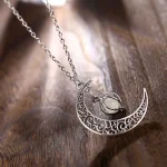 Halsband med månpendel i metall med fint graverat mönster och central sten, idealiskt för en elegant och mystisk touch.