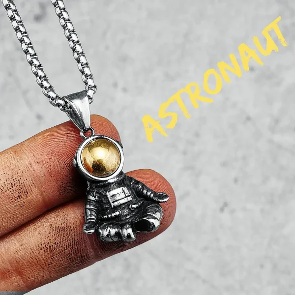 Halsband med astronauthäng i försilvrad metall och gyllene kula, inspirerat av rymden och rymdutforskning.