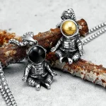 Astronauthäng i metall med gyllene och svarta kulor, hängande på en kedja, inspirerade av rymden och rymdutforskning.