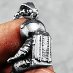 Hänge i form av en astronaut i försilvrad metall, detaljerad med hjälm och ryggsäck, perfekt för rymd- och vetenskapsentusiaster.
