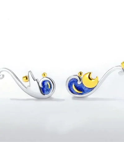 Celestri dekorationstillbehör i silver- och guldmetall med mönster av moln och måne.