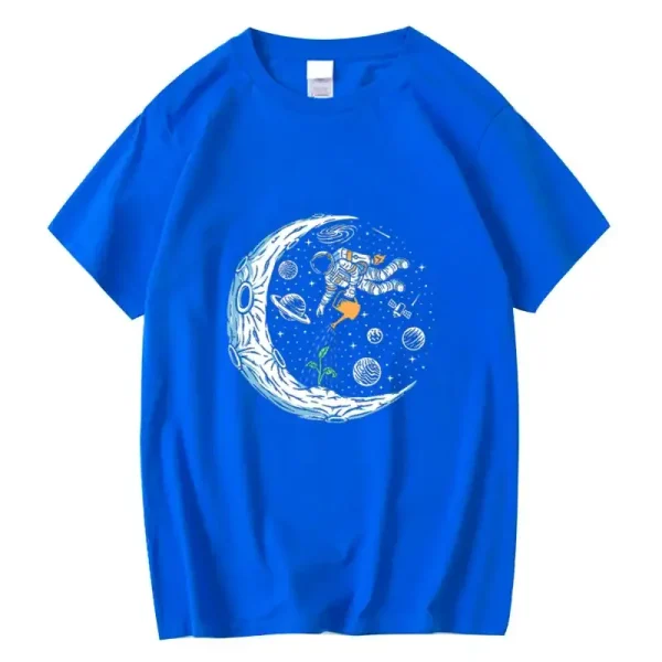 Blå t-shirt med mönster av en astronaut som svävar i rymden, omgiven av planeter, stjärnor och en stiliserad måne. Perfekt för vetenskaps- och astronomientusiaster.