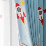 Barngardin med mönster av röd raket och gula stjärnor, dekorativ för barnrum eller lekfullt utrymme. Lätt att fästa och underhålla, ger en rymdliknande touch till inredningen.