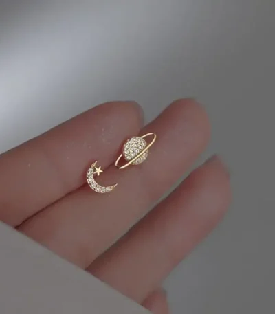 Örhänge i form av måne och stjärna prydda med diamanter, som symboliserar celestialitet och elegans.