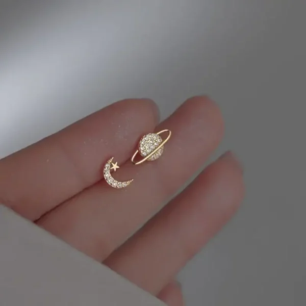 Örhänge i form av måne och stjärna prydda med diamanter, som symboliserar celestialitet och elegans.