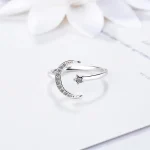 Silverring med måne- och stjärnmönster inlagda med kristaller, elegant och delikat design, perfekt för en touch av magi och vetenskap i din stil.
