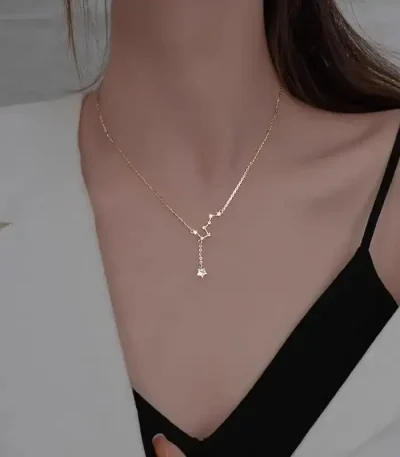 Delikat halsband med vetenskapligt hängsmycke i guld, buren av en kvinna, perfekt för vetenskaps- och sofistikerade smyckenälskare.