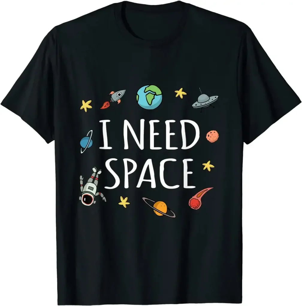 Kolla in denna svarta t-shirt med texten "I NEED SPACE" omgiven av teckningar av planeter, stjärnor, en raket, en astronaut och en UFO, perfekt för astronomi- och vetenskapsentusiaster.