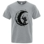 Grå t-shirt med illustration av en astronaut på månen, konstnärlig och modern stil, perfekt för vetenskaps- och astronomientusiaster.
