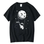 Svart t-shirt med illustration av en liten astronaut som håller en måne i form av en ballong, i en enkel och söt grafisk stil, perfekt för rymd- och vetenskapsentusiaster.