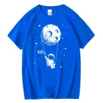 Blå t-shirt med design av astronaut som hänger vid månen, lekfull och original rymdatmosfär.
