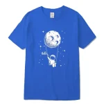 Blå t-shirt med illustration av en astronaut som hänger vid månen, omgiven av stjärnor, med ordet "Hello" skrivet bredvid. Lekfull och vetenskaplig design för rymdentusiaster.
