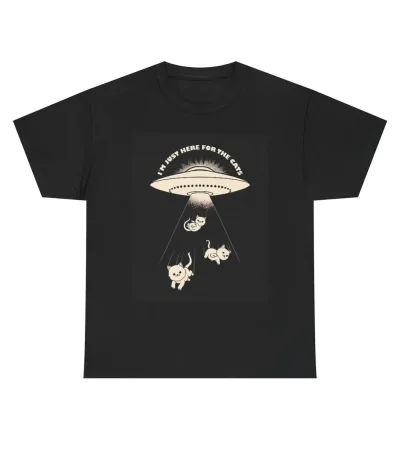 Svart t-shirt med illustration av ett UFO och tre djur under en ljusstråle, texten "I must be here for the cake" högst upp.