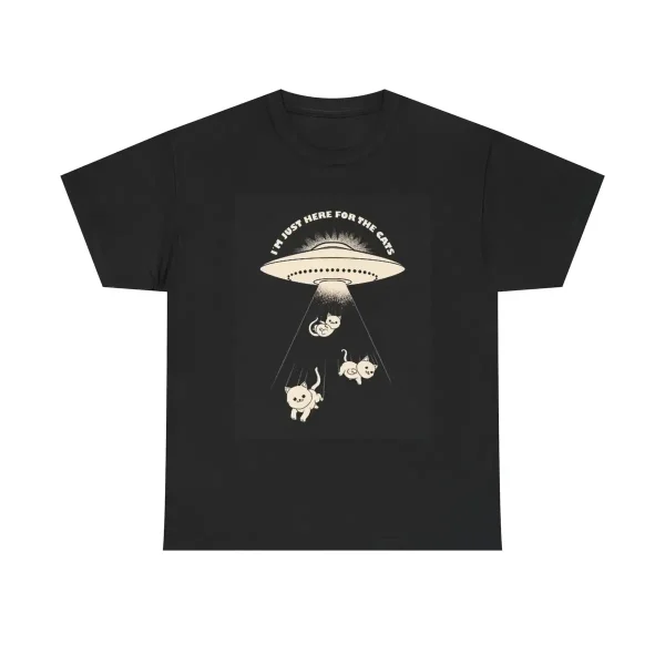 Svart t-shirt med illustration av ett UFO och tre djur under en ljusstråle, texten "I must be here for the cake" högst upp.