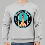 Grå sweatshirt med Falcon Heavy SpaceX-logotyp, illustration av en raket i uppskjutning i en modern grafisk stil, idealisk för rymd- och teknikentusiaster.