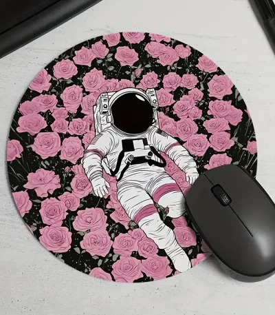 Illustrerad astronautdräkt som ligger på en rund matta med rosa och svarta rosor, med en svart datormus bredvid.