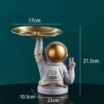 Originell köksredskapsställ i form av en astronaut med en gyllene bricka, perfekt för köksdekoration eller som vetenskapligt samlarobjekt. Unik och rolig design för rymdentusiaster.