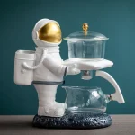 Plastfigur av astronaut med ett glaslaboratorium, vetenskaplig och rymdrelaterad dekoration.