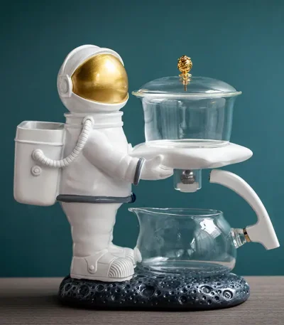 Plastfigur av astronaut med ett glaslaboratorium, vetenskaplig och rymdrelaterad dekoration.