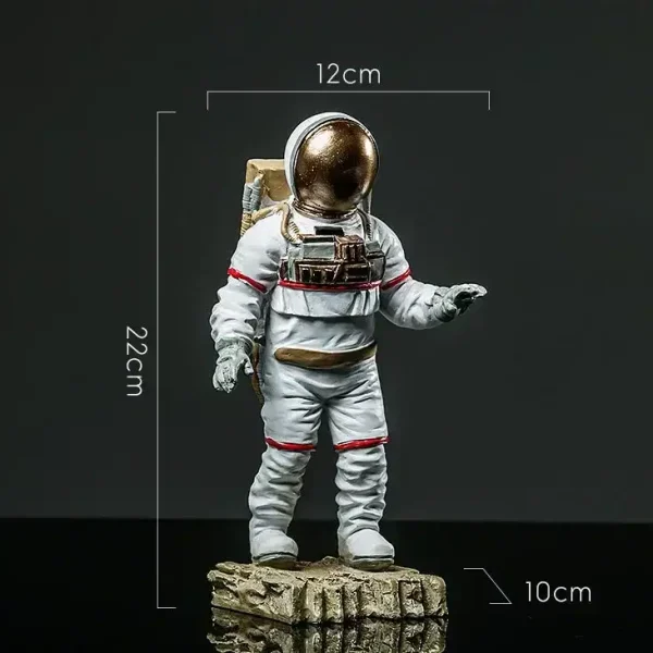Miniatyrfigur av astronaut med gyllene hjälm, 22 cm hög, 12 cm bred och 10 cm djup, placerad på en stenig bas, idealisk för vetenskaplig dekoration.