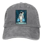 Mörkgrå bomullskeps med broderad astronaut som bär två ryggsäckar, science fiction-stil, original och dekorativ modeaccessoar.