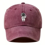 Rosa keps med tecknad astronautlogotyp, original och trendig modeaccessoar för vetenskaps- och rymdentusiaster.