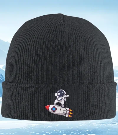 Svart keps med broderi av en utomjording i rymddräkt på en raket. Original modeaccessoar inspirerad av rymden och science fiction.