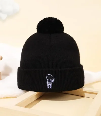 Svart ullmössa med pom-pom och astronautlogotyp, perfekt för vetenskaps- och astronomientusiaster, idealisk för vintern eller som vetenskaplig dekoration.