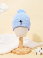 Ljusblå ullmössa med ett litet broderat vetenskapsmotiv, prydd med en pompom på toppen. Perfekt för vetenskaps- och vintermodeentusiaster.