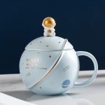Keramikkopp med rymdmotiv, dekorerad med stjärnor och planeter, idealisk för astronomi- och science fiction-entusiaster, med en design inspirerad av universum.