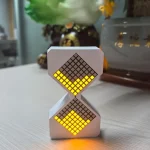 Dekorativ klocka i form av en pixelklocka med gult LED-ljus, perfekt för vetenskaplig eller modern inredning.
