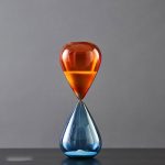 Färgglad sandklocka i glas, elegant vetenskaplig dekoration för kontor eller hem.