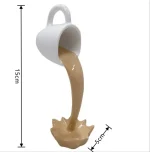 Liten vit kopp som häller ut en beige vätska som simulerar ett vetenskapligt fenomen, mäter 15 cm hög och 5 cm bred.