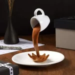 Original kaffekopp i form av en spruta, med chokladvätska som rinner ner i en tallrik, idealisk för köksdekoration eller en ovanlig present.