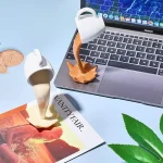 Dekorativ kaffekopp i form av utbrott av vätska, inspirerad av vetenskapliga experiment, idealisk för kontors- eller köksdekoration.