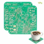 Grönt elektroniskt kretskort för laboratorie- eller vetenskapsverkstad, tillsammans med en kaffekopp på en platta i kretskort.