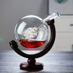 Glasglob med röd vätska och ett vetenskapligt objekt, placerad på en träställning, dekorativ och pedagogisk.