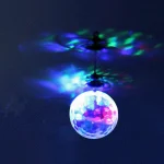 Hängande lampa i form av en boll som projicerar färgglada ljus på taket, vilket skapar en ljus och konstnärlig atmosfär.