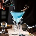 Transparent glasvas med stöd i form av tentakler, idealisk för vetenskaplig eller modern dekoration.