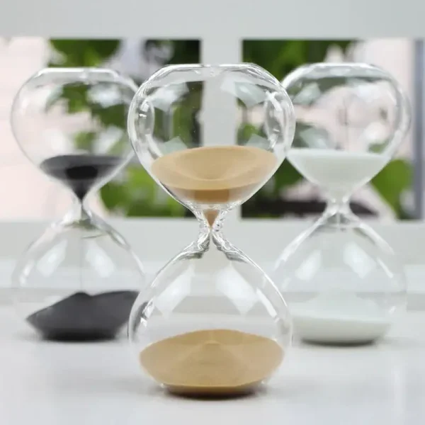 Glasstopp i glas med vit och svart sand, symboliserar tidens gång, dekorativ och vetenskaplig, idealisk för kontors- eller hylldekoration.
