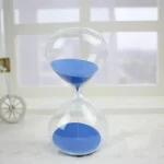 Laboratorietopp med blå sand, symboliserar tidens mätning, idealisk för vetenskaplig eller pedagogisk dekoration.