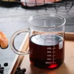 Laboratoriekopp i glas som innehåller en mörk vätska, graderad för att mäta volymen exakt, idealisk för vetenskapliga experiment eller temadekor.