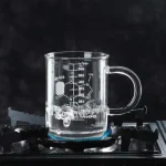Mätglas i glas som innehåller en kokande vätska, placerad på en gasplatta, som illustrerar ett vetenskapligt objekt för dekoration eller studier.