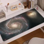 Skrivbordspanel med galaxtryck, som visar en spiral av universum med stjärnor och nebulosor.