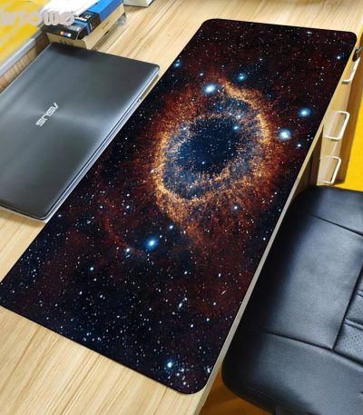 Skrivbordsmatta med galaxmönster, som föreställer en bild av universum med stjärnor och en nebulosa, idealisk för vetenskaplig dekoration eller utrymme.