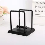 Newtonpendel i svart metall med träbas, idealisk för vetenskaplig eller utbildande dekoration, som ger en modern och elegant touch till ditt hem.