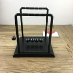 Newtonpendel i trä och metall, vetenskaplig dekoration för kontor eller inomhus.