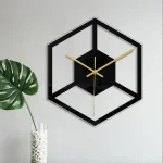 Väggklocka med design i kubform med svart ram och gyllene visare, perfekt för modern inredning.