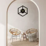 Väggklocka i form av en kub med minimalistisk design, svart och guld, som ger en samtida touch till inredningen.