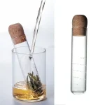 Laboratoriepipett omvandlad till teinfuser, innehållande grönt te i infusion. Perfekt för en original vetenskaplig dekoration eller en innovativ teprovning.